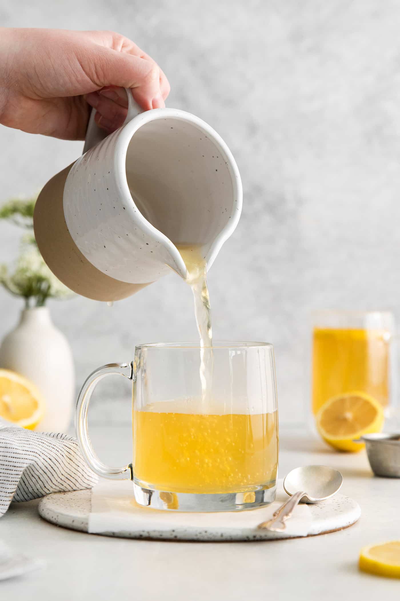 Tea being poured into a glass mug