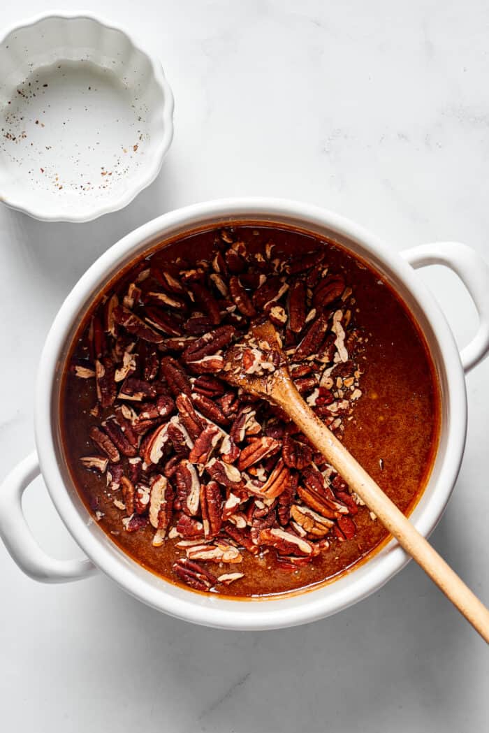 Pecans being added to a praline candy mixture