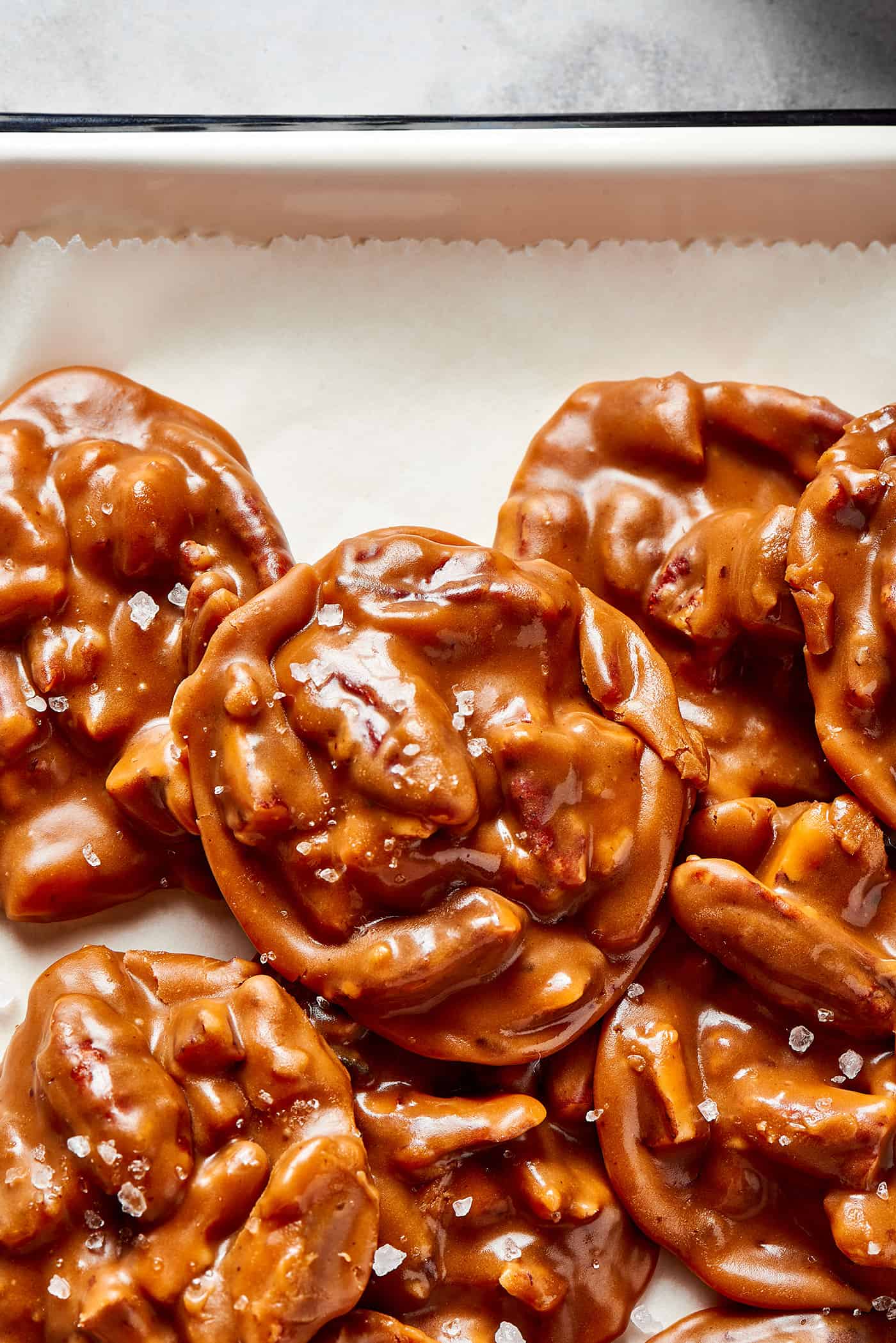 overhead view of a pile of pecan pralines on a white platter