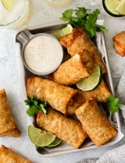 Overhead view of southwest egg rolls on a tray with lime crema