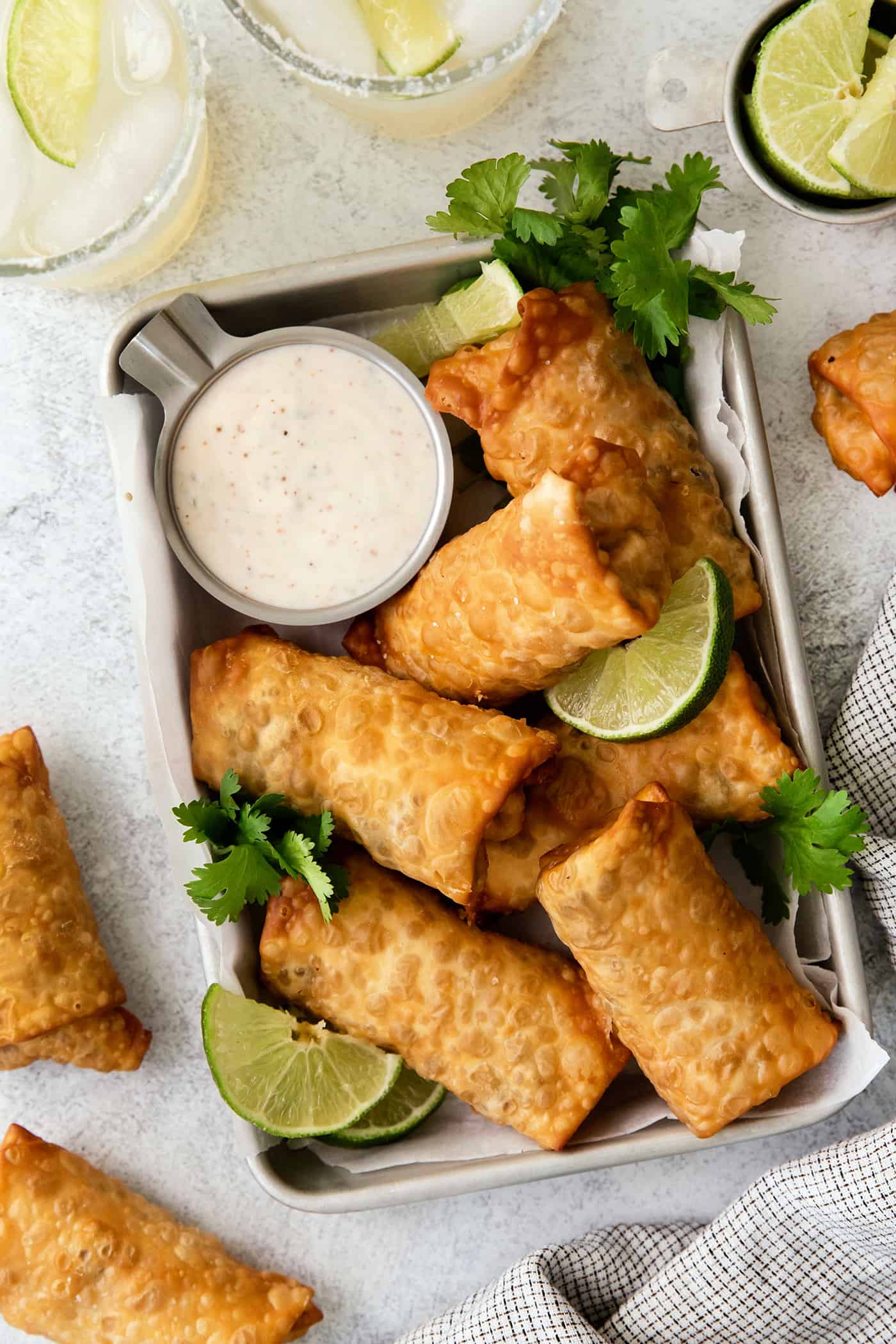 Overhead view of southwest egg rolls on a tray with lime crema