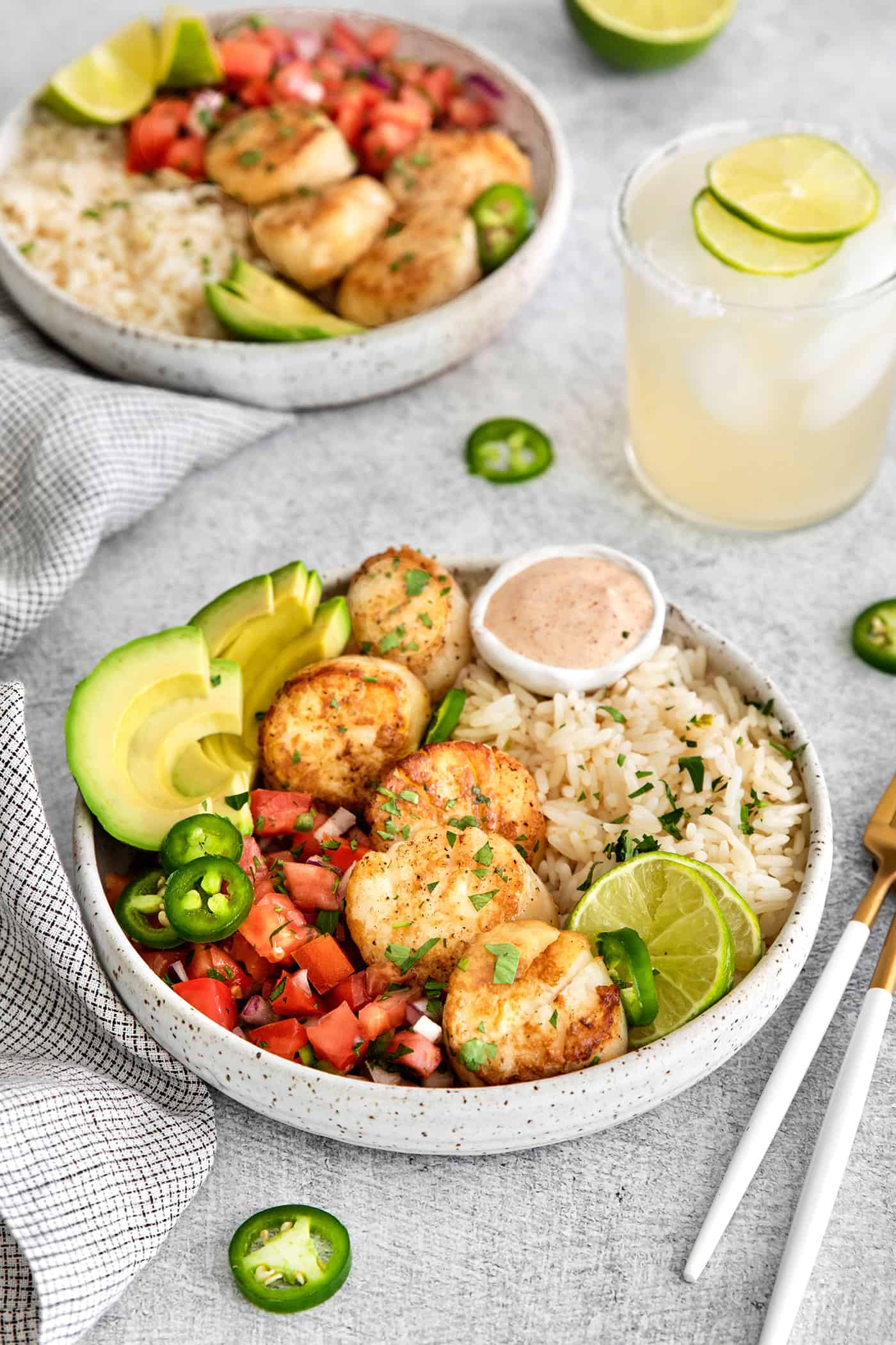 These Tex-Mex Scallop Rice Bowls are bright, refreshing, and packed with flavor, with scallops, pico de gallo, and lime crema. Overhead view of a Tex-Mex scallop rice bowl