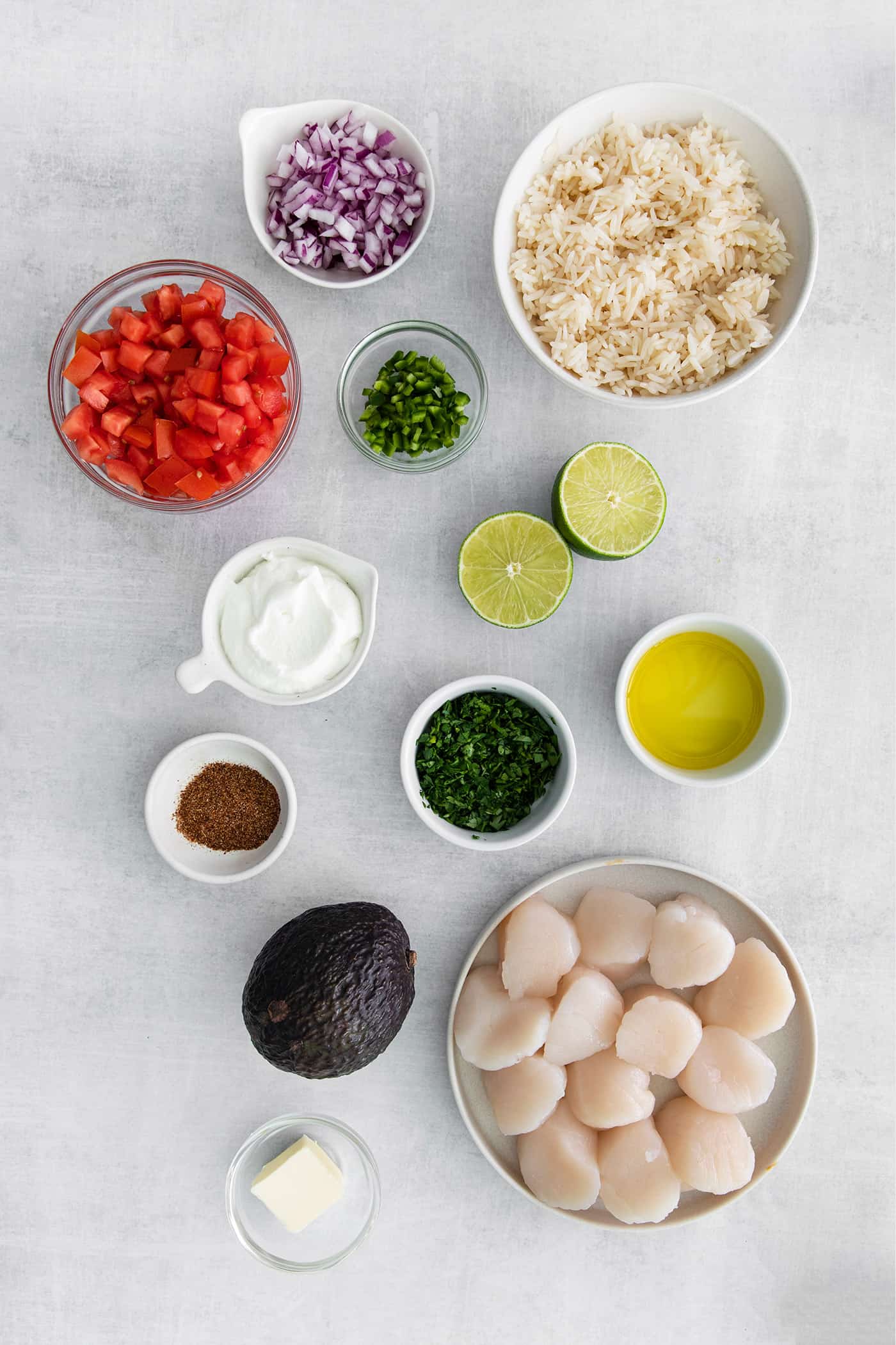 Overhead view of ingredients to make lime rice, lime crema, pico de gallo, and seared scallops