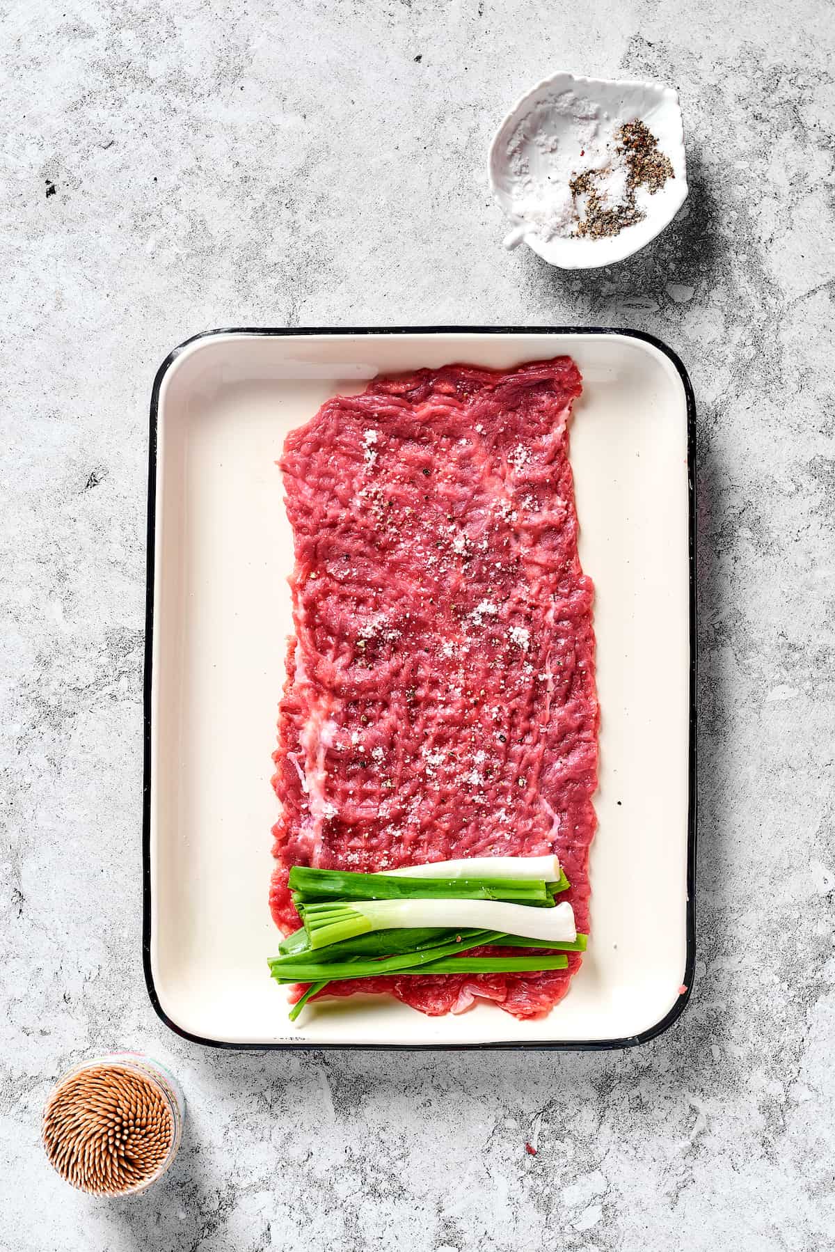 Scallions on a piece of raw steak