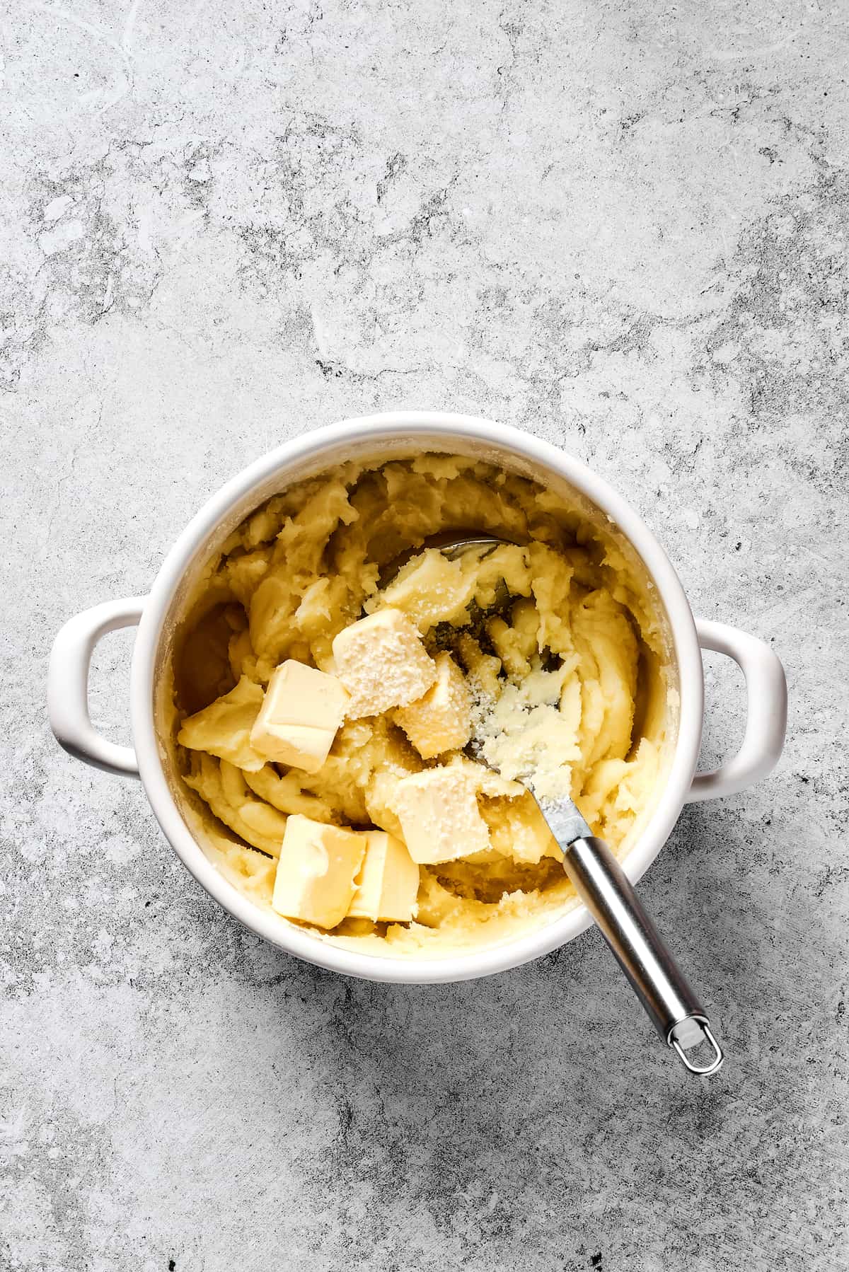 Potatoes being mashed with butter