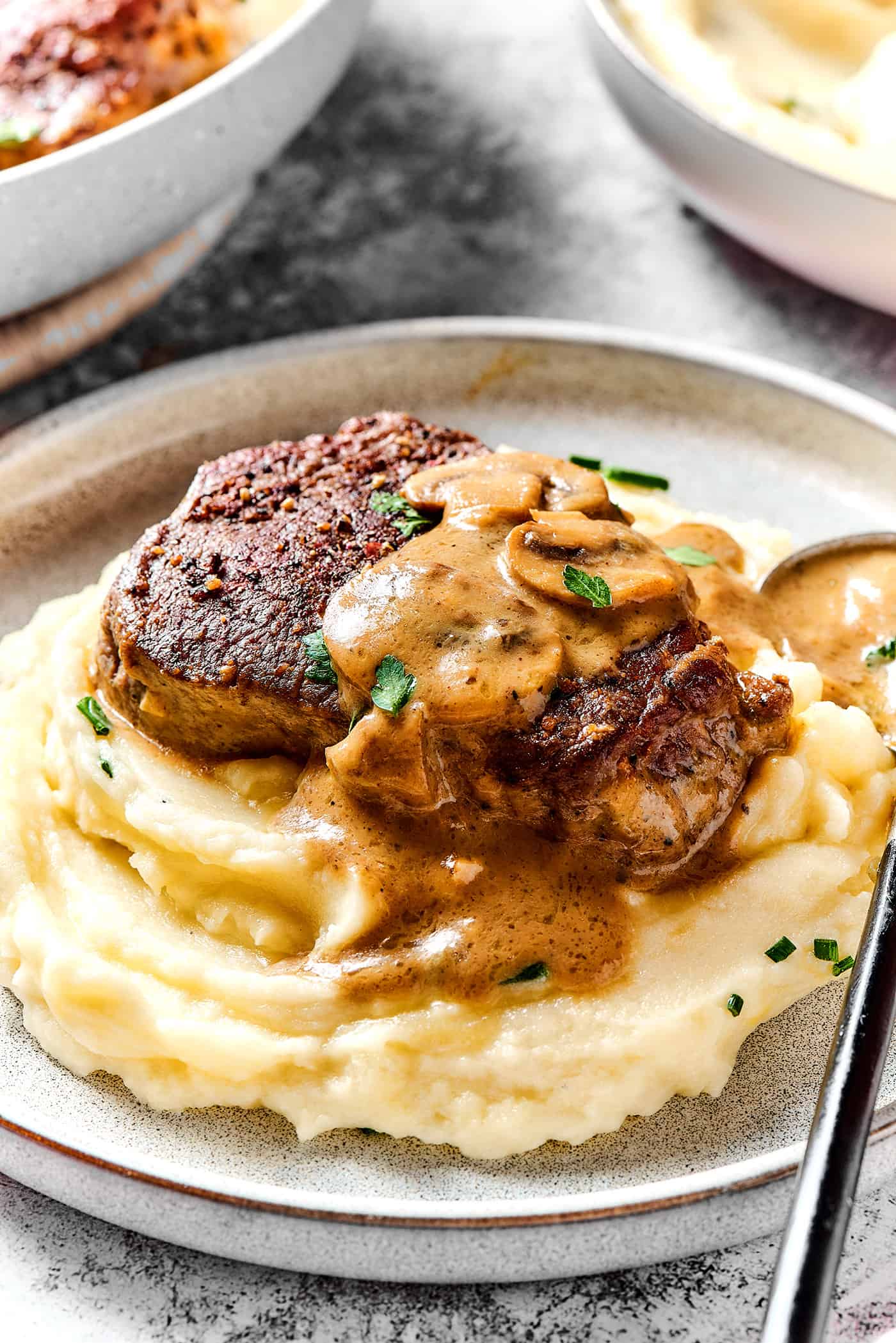 a steak with creamy mushroom sauce over mashed potatoes