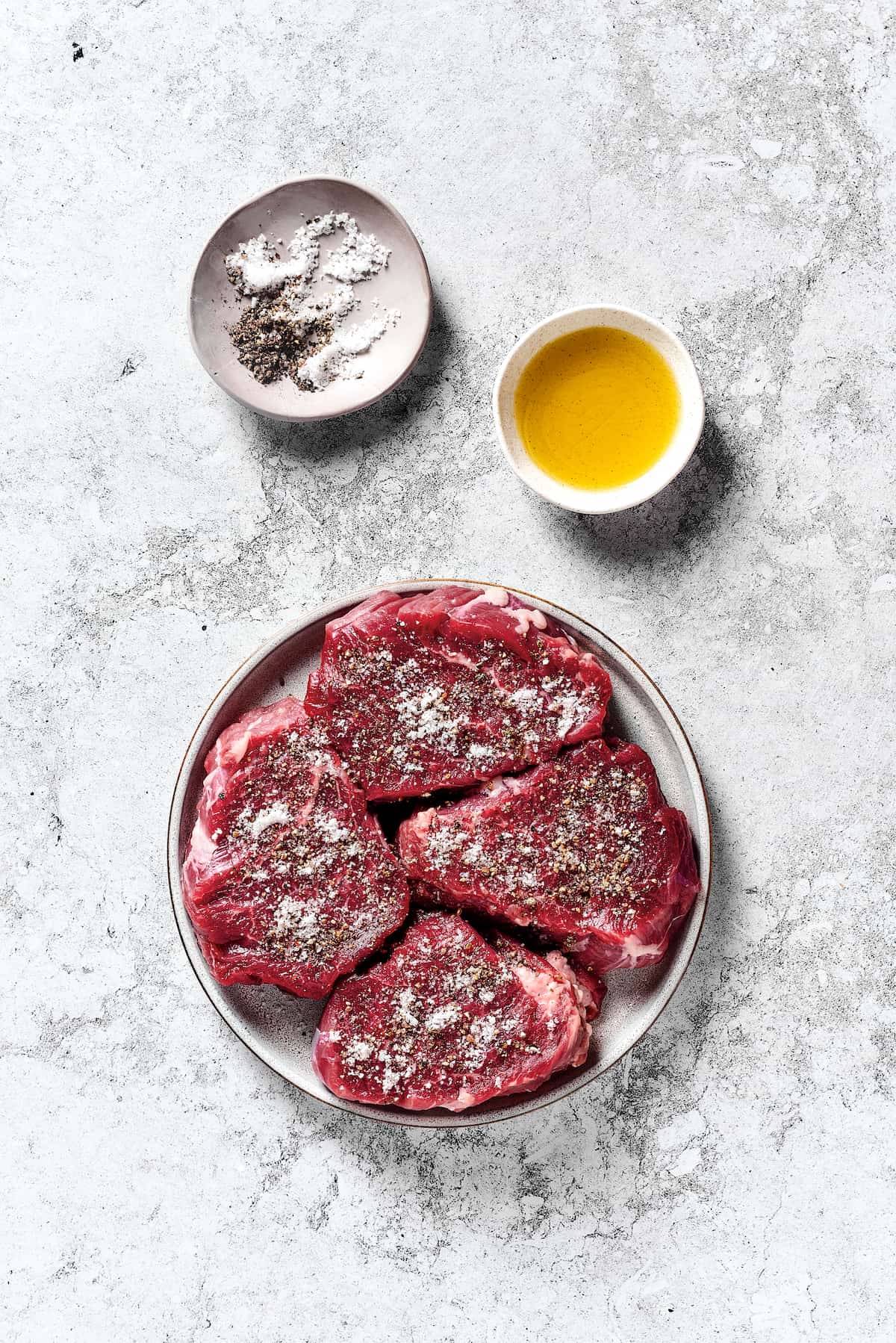 Beef tenderloin seasoned with salt and pepper on a plate