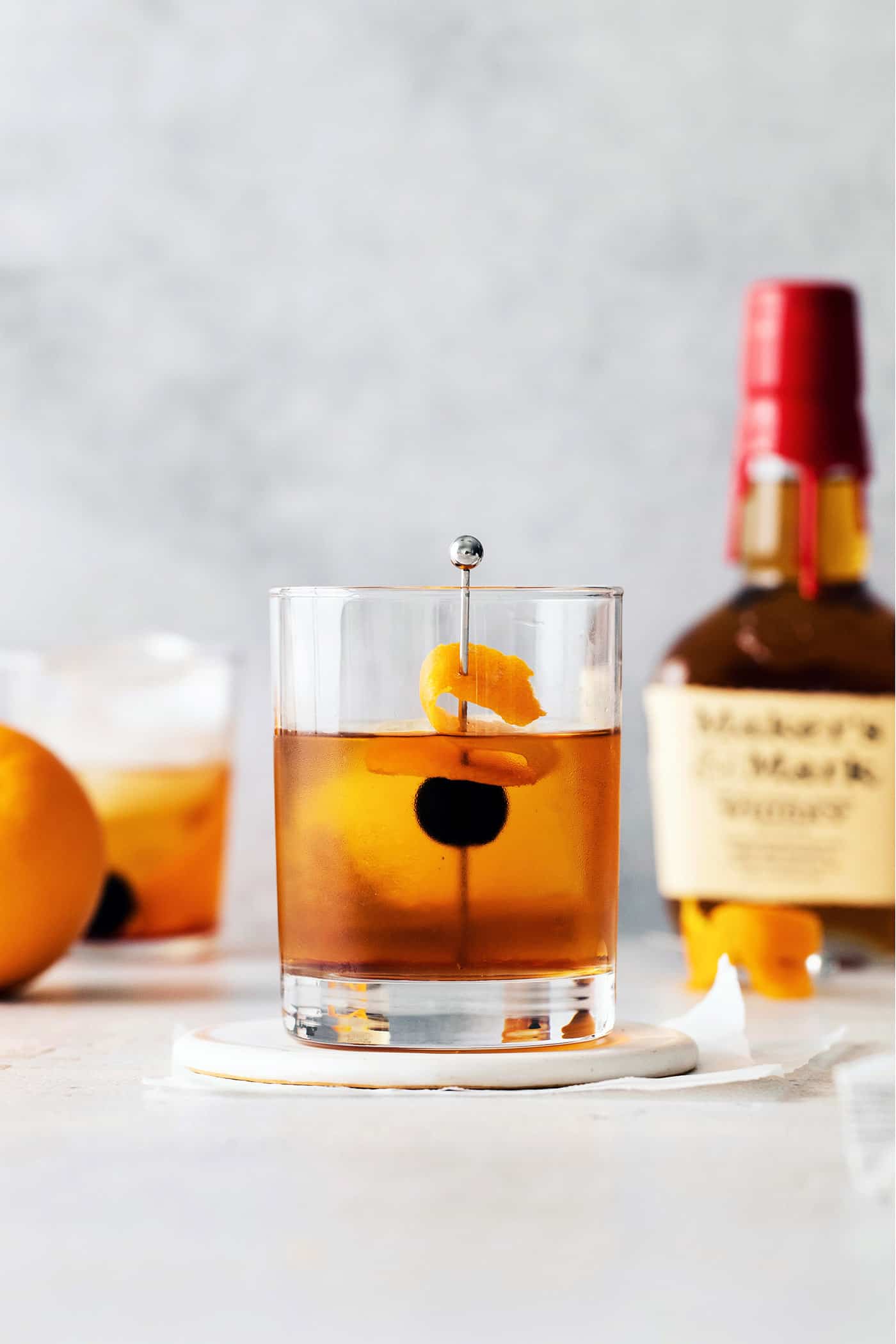 A manhattan cocktail in front of a bottle of whiskey