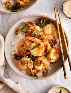 Honey walnut shrimp over rice on a white plate