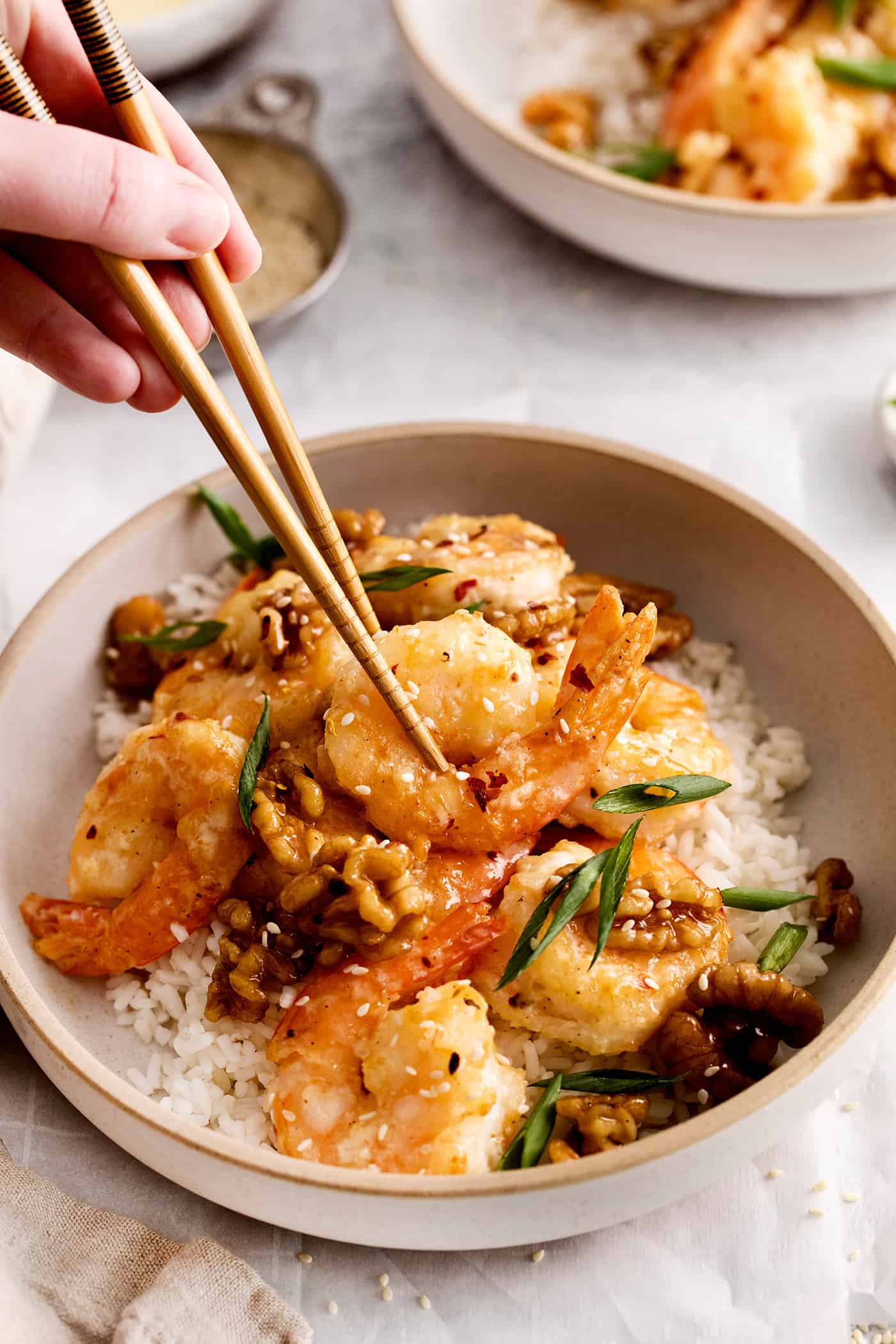 Chopsticks grabbing a piece of honey walnut shrimp