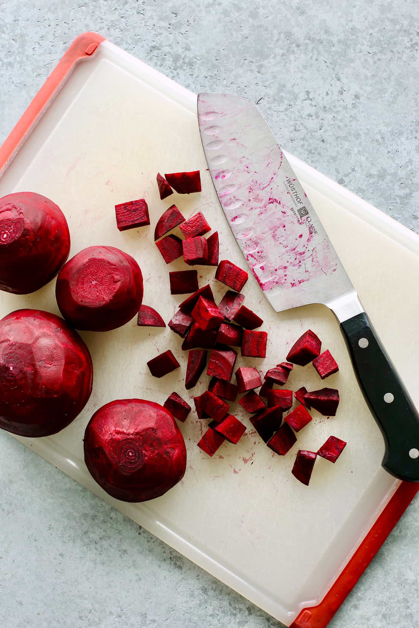 beets on a cutting board with a large knife