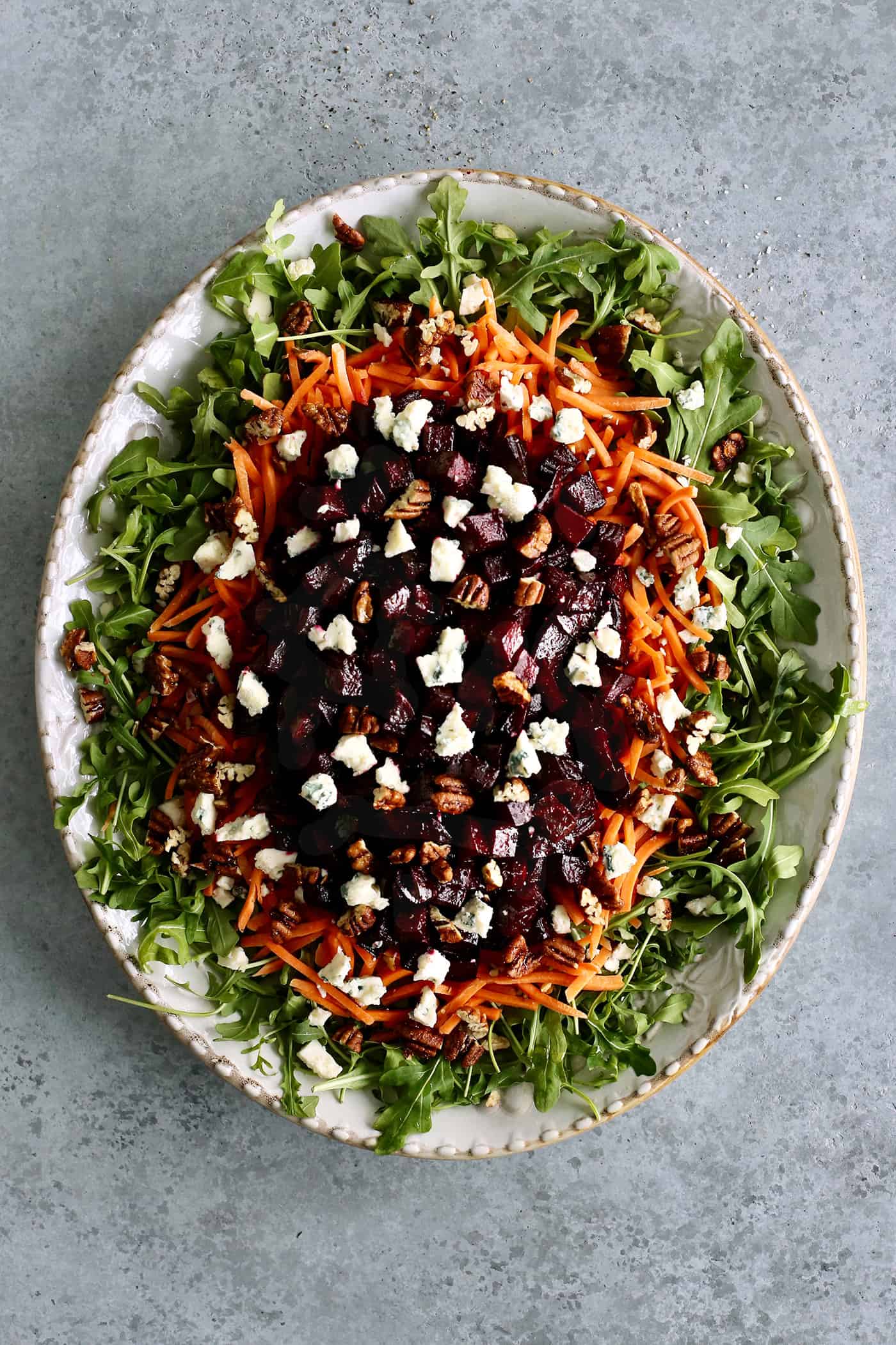 overhead view of a salad arranged on a large oval platter