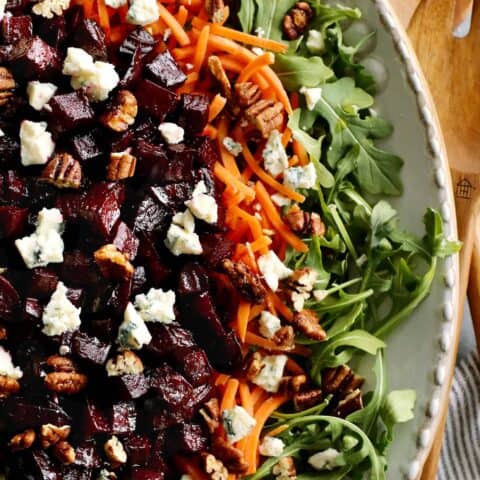 overhead of photo of a large salad with beets, arugula, and carrots