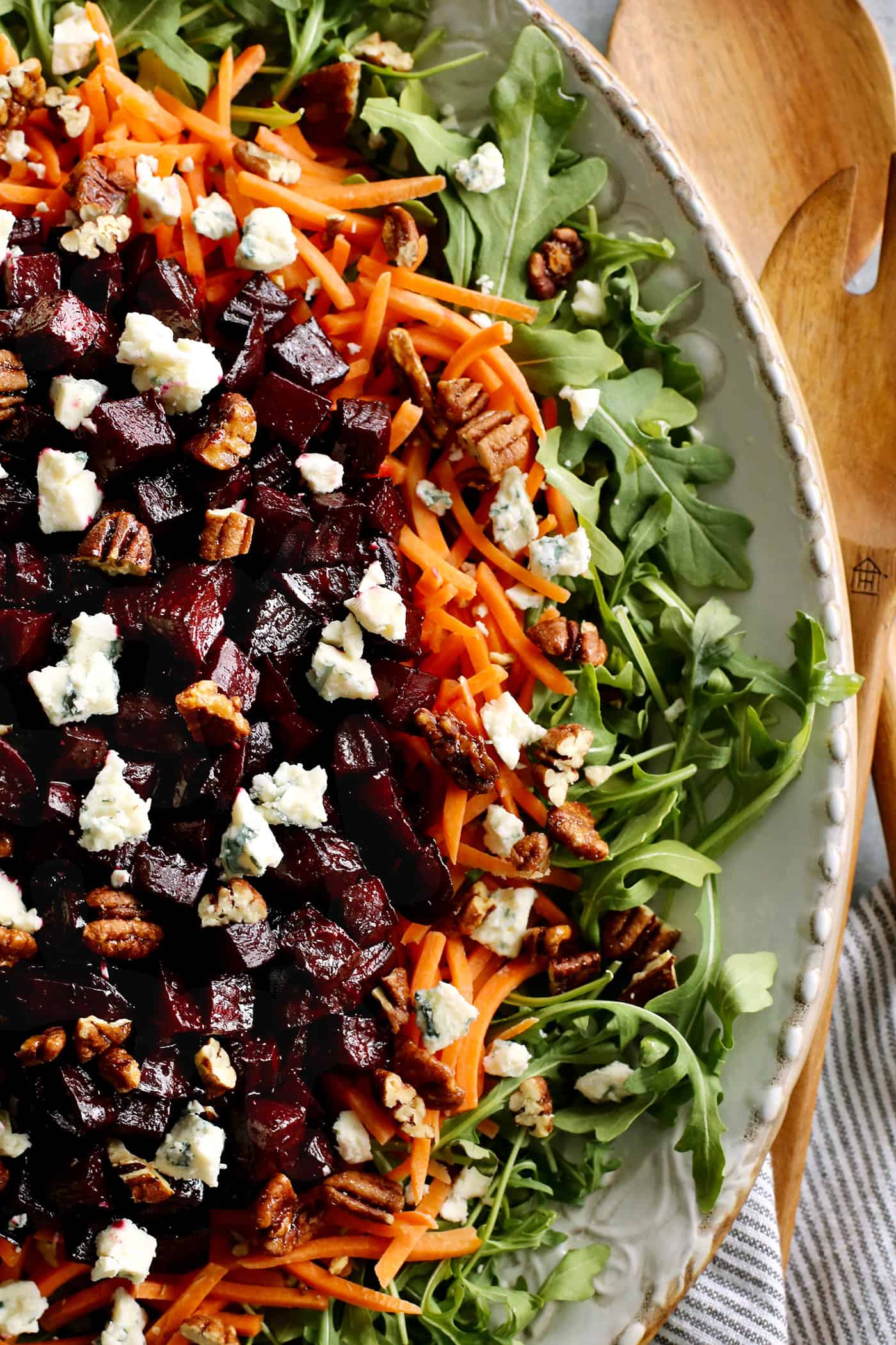 overhead of photo of a large salad with beets, arugula, and carrots