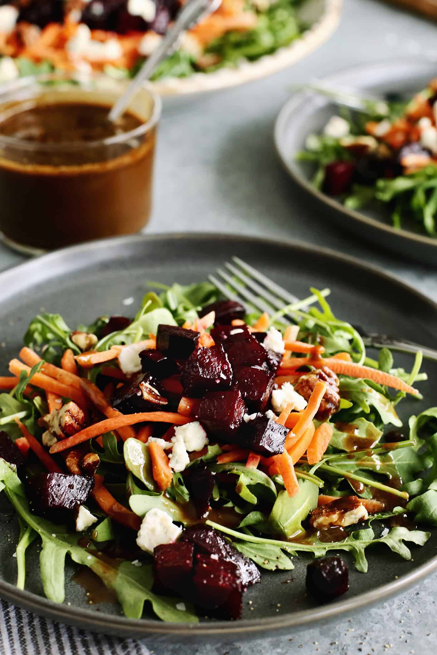 an individual plate of arugula salad with roasted beets