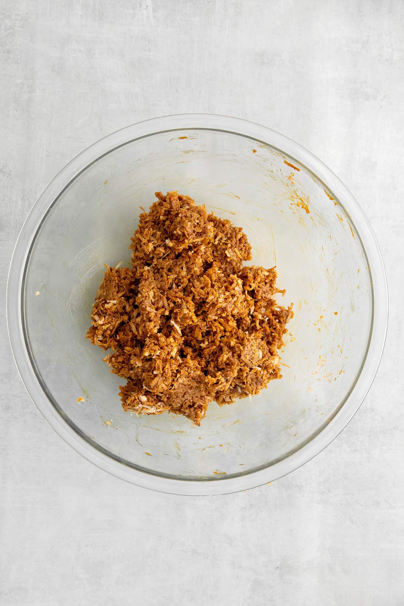 Toasted coconut mixed with dulce de leche in a bowl