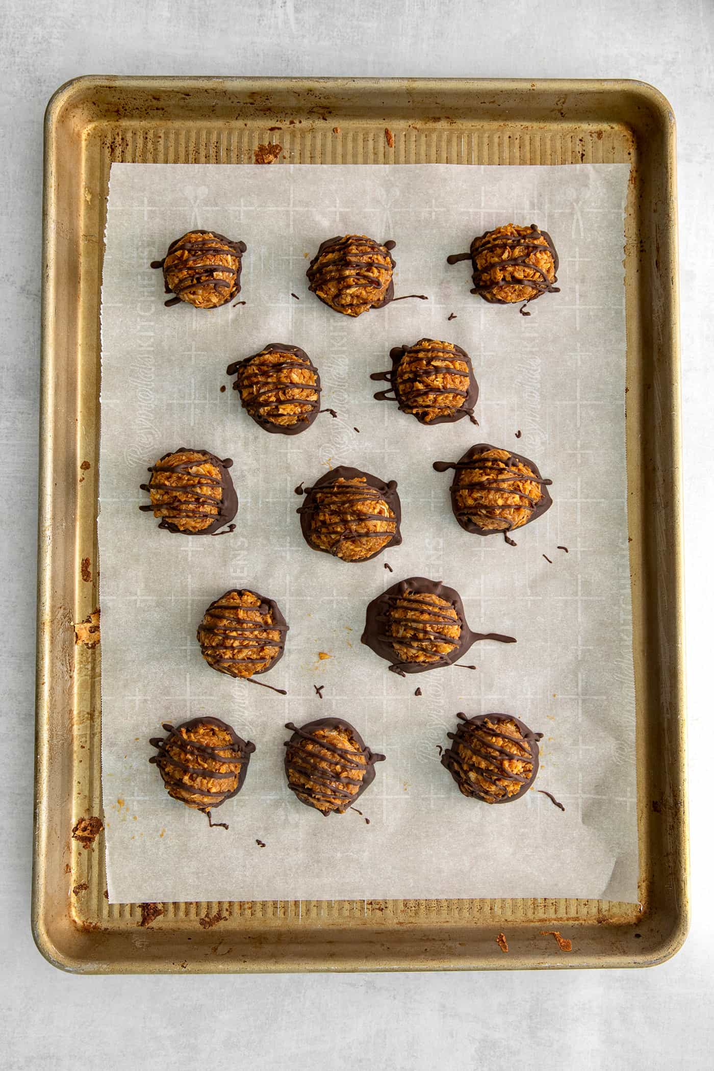 Chocolate dipped dulce de leche macaroons on a baking sheet