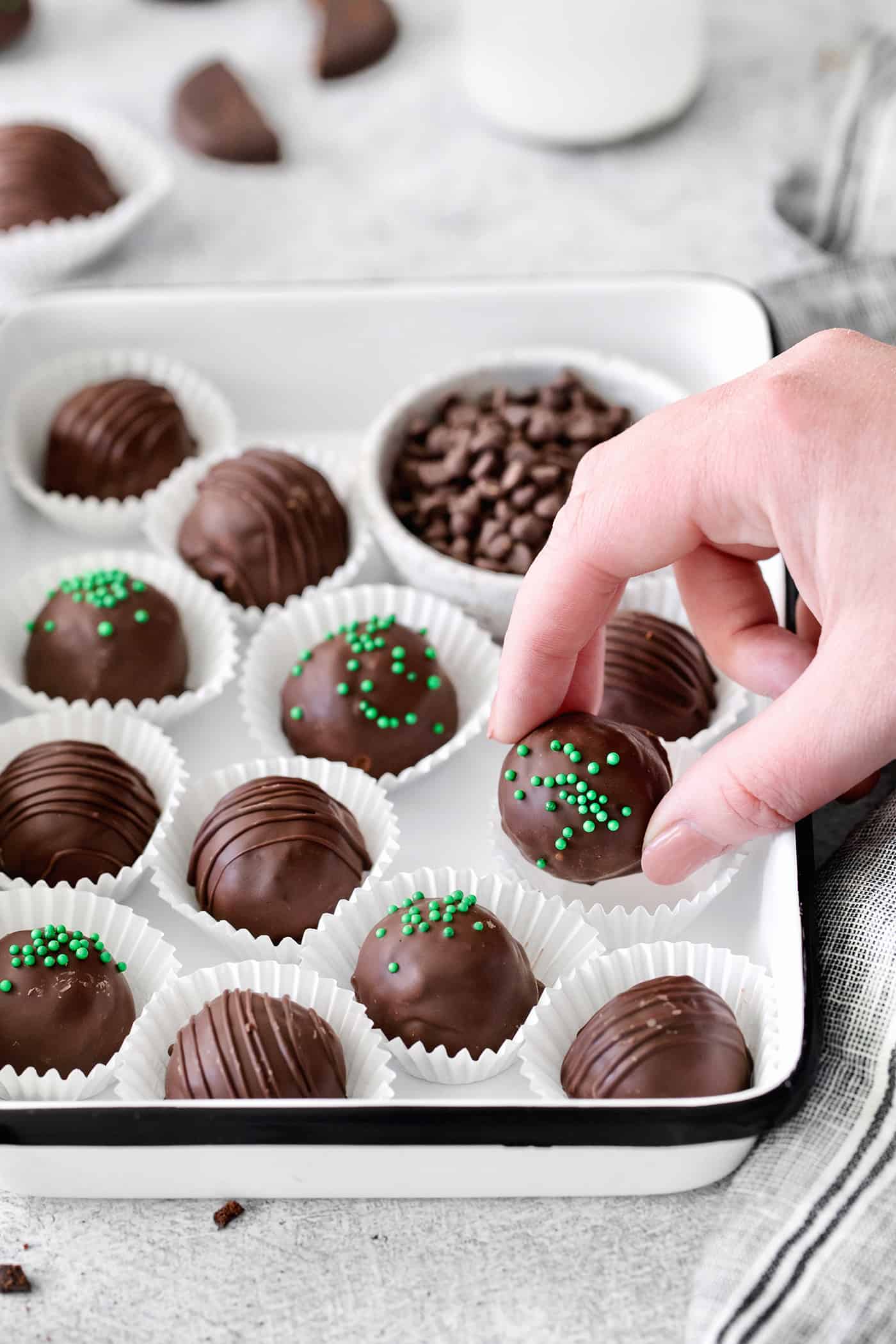 A hand grabbing a chocolate truffle