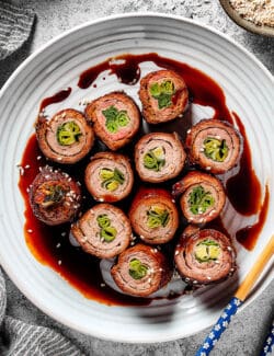 beef negimaki rolls on a white plate with chopsticks