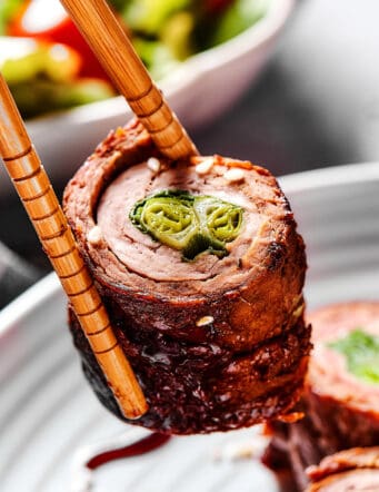 beef negimaki held by chopsticks