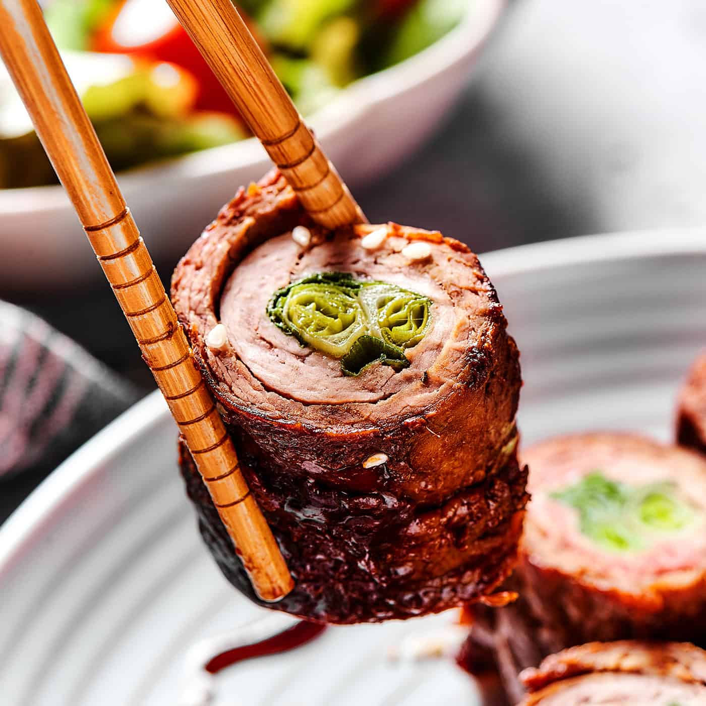 beef negimaki held by chopsticks