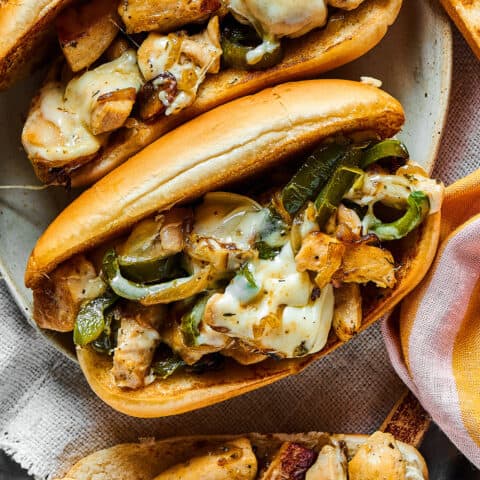 overhead photo of assembled sandwich with a hoagie roll, chicken, green pepper, and melted cheese