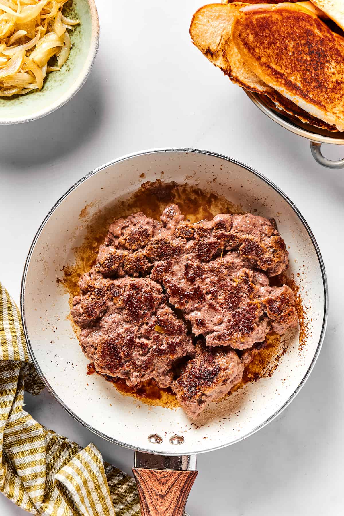 A large patty of ground beef in a frying pan