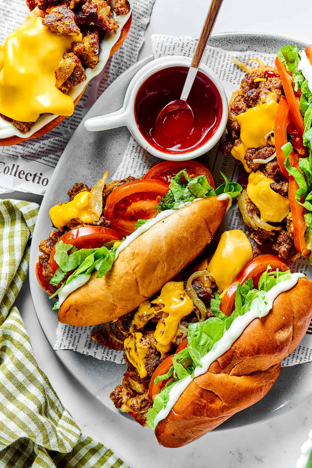 Overhead view of two chopped cheese sandwiches on a plate with ketchup