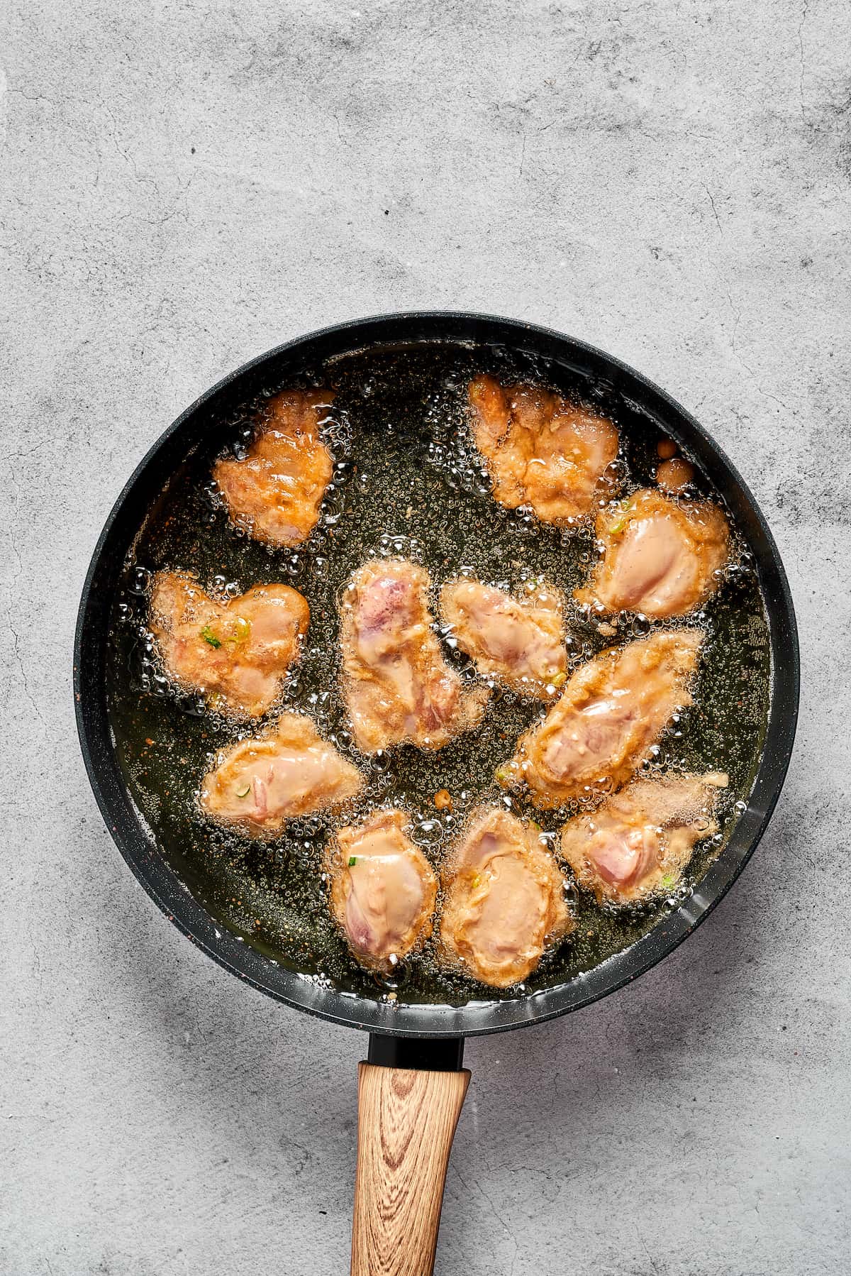 Pieces of mochiko chicken fryign