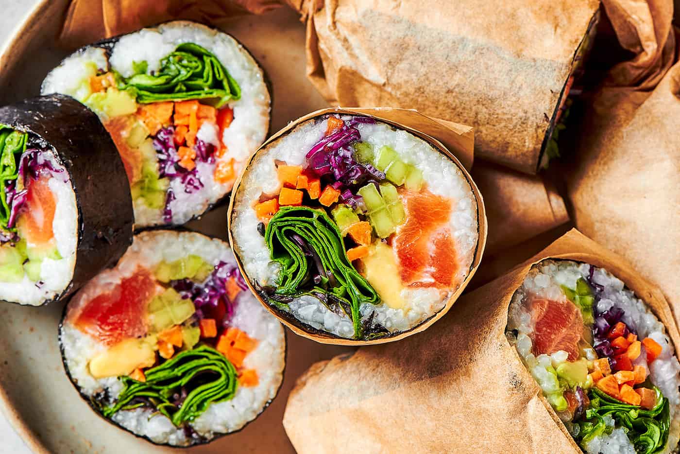 sushi burritos cut in half on a platter