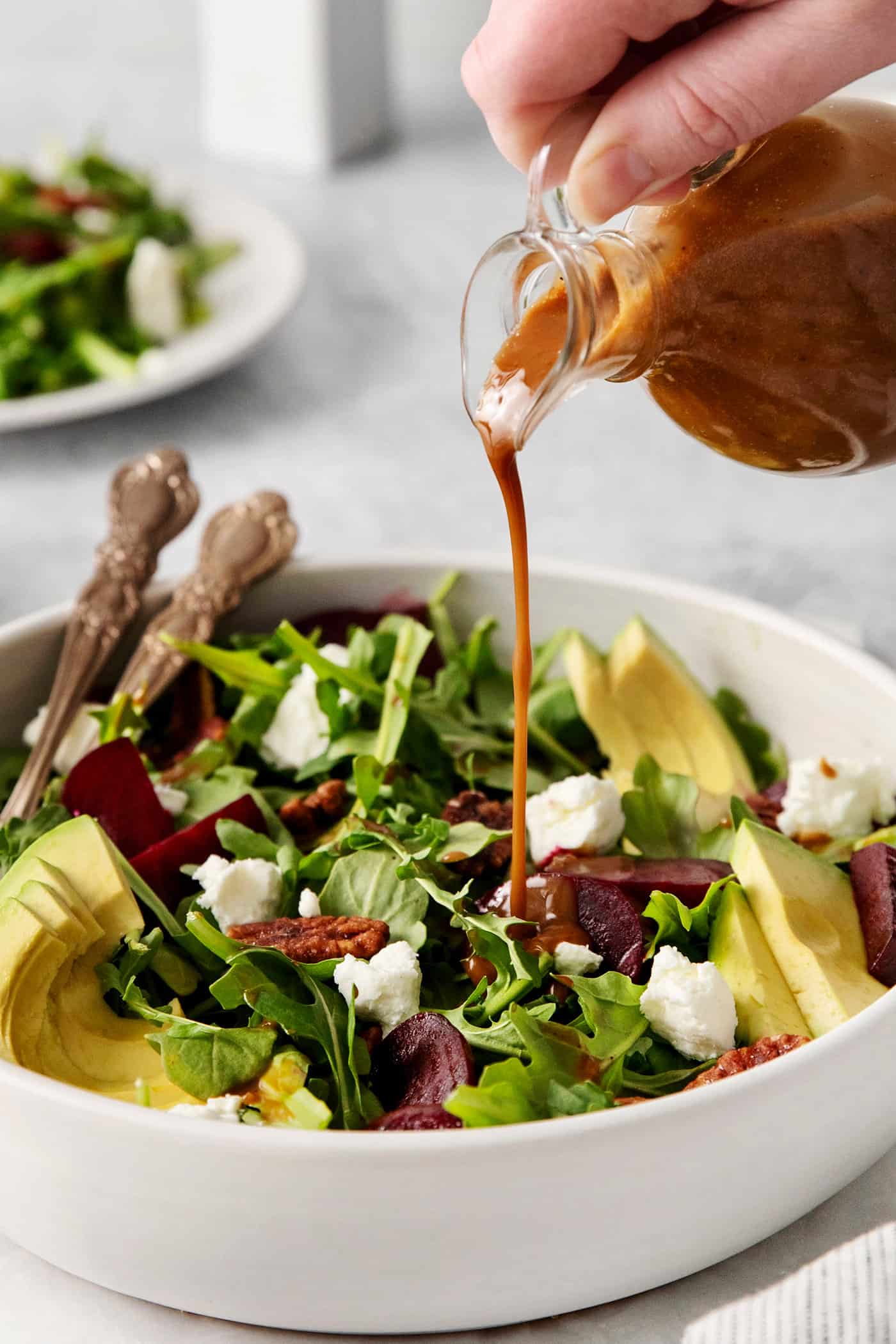 Balsamic vinaigrette dressing being poured over a salad