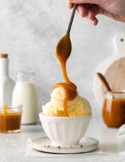 Caramel buttermilk syrup being drizzled over a dish of vanilla ice cream