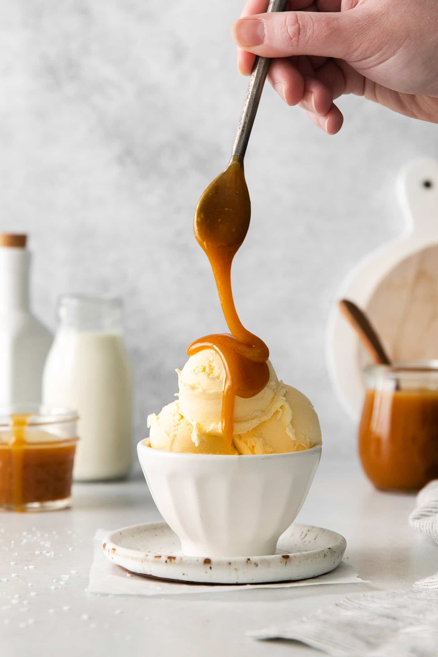 Caramel buttermilk syrup being drizzled over a dish of vanilla ice cream