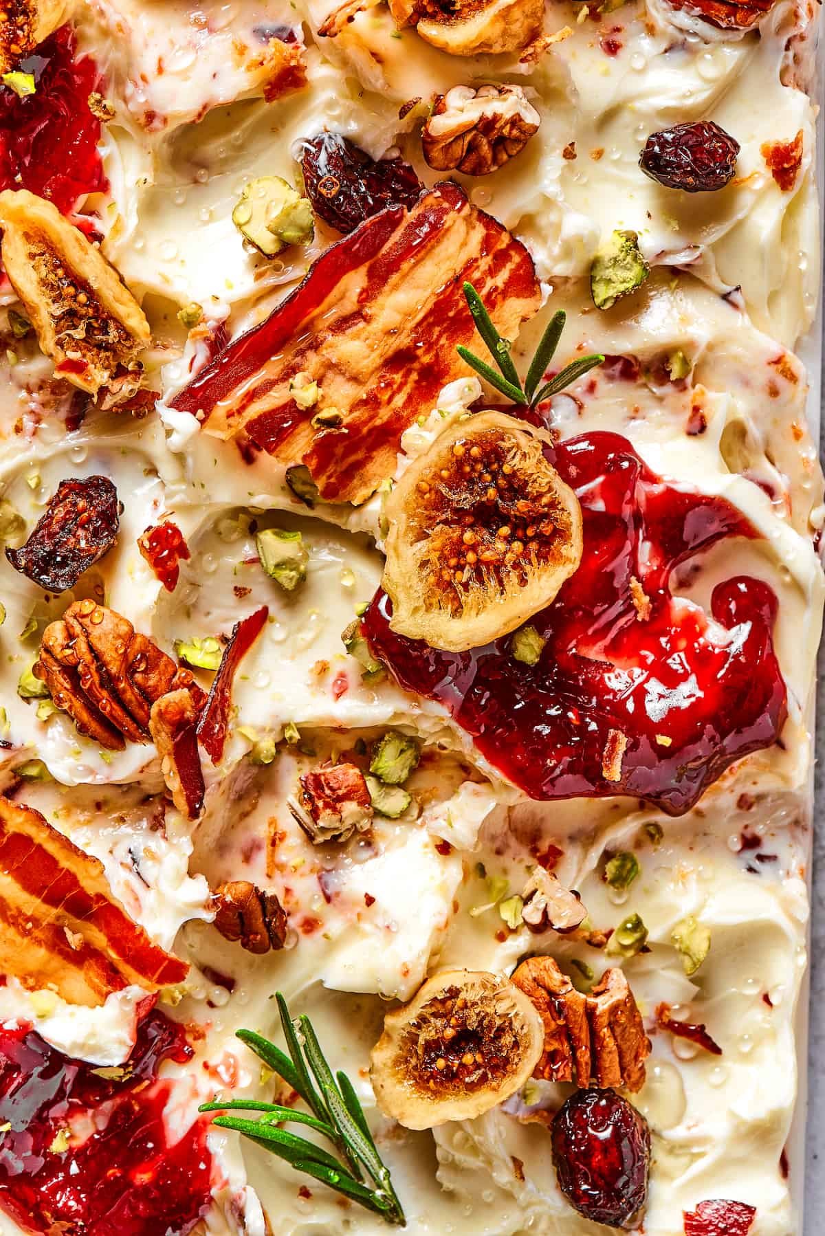 Close up of a butter board with bacon, dried fruits, and jam