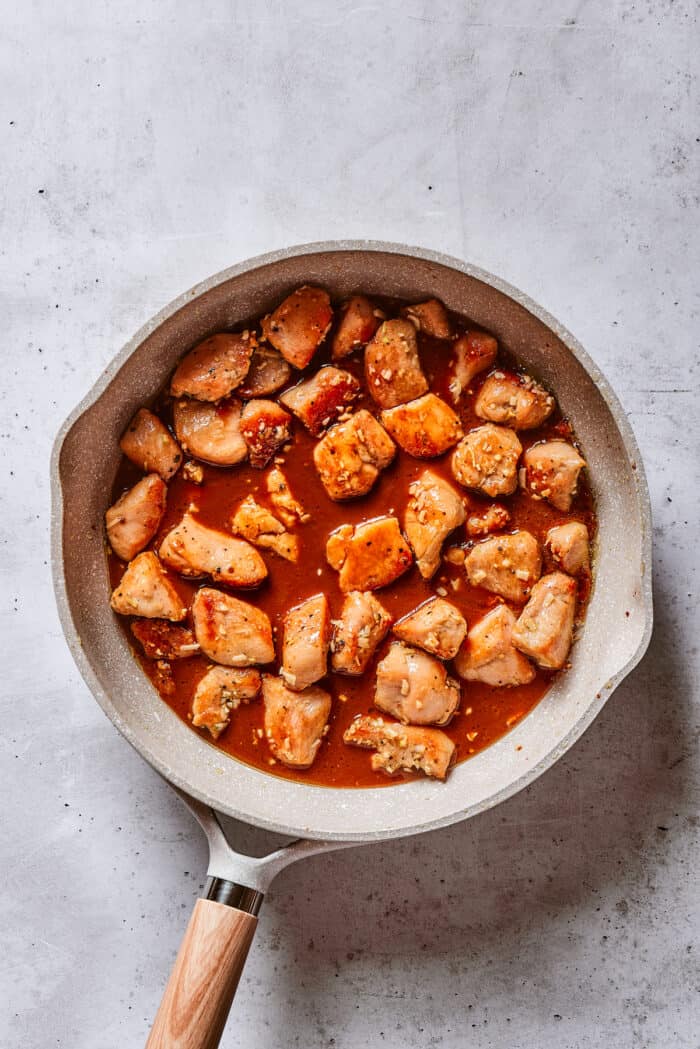 Chunks of chicken breast in a sauce in a frying pan