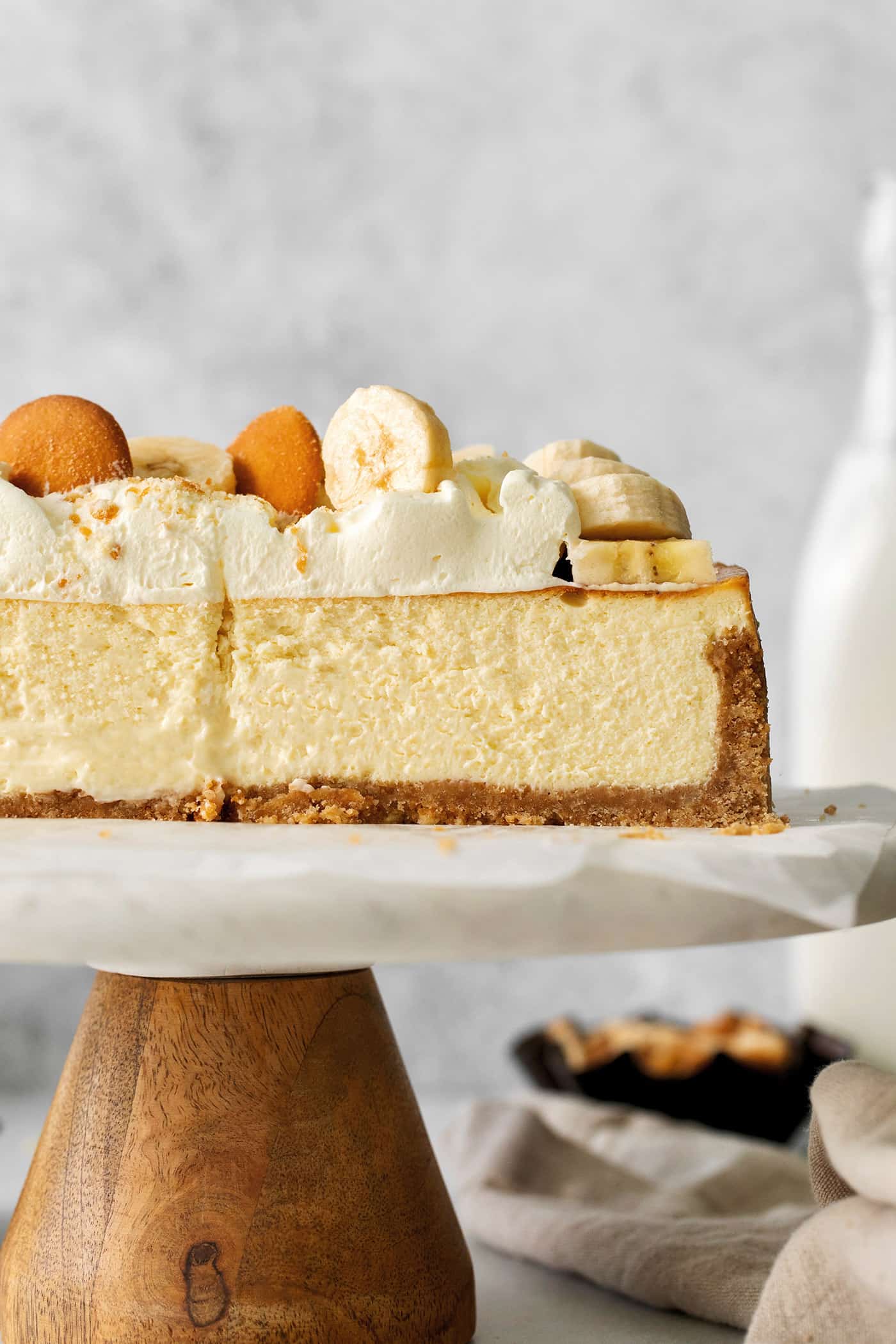 Side view of a sliced banana cheesecake on a serving platter