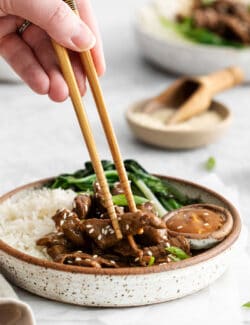 Chopsticks diving into a beef bulgogi rice bowl