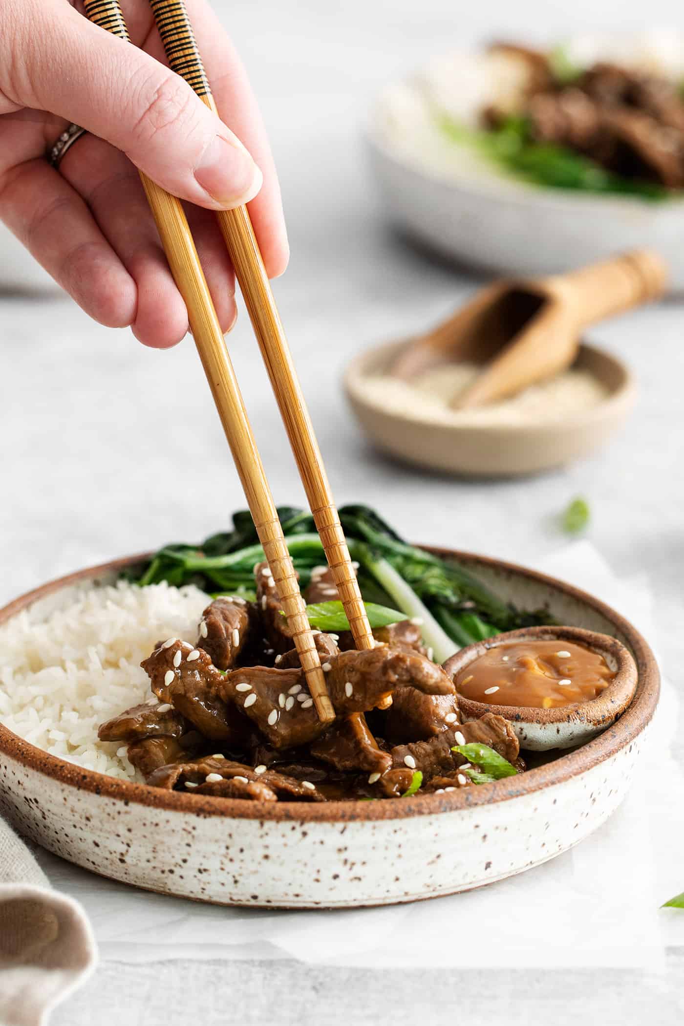 Chopsticks diving into a beef bulgogi rice bowl