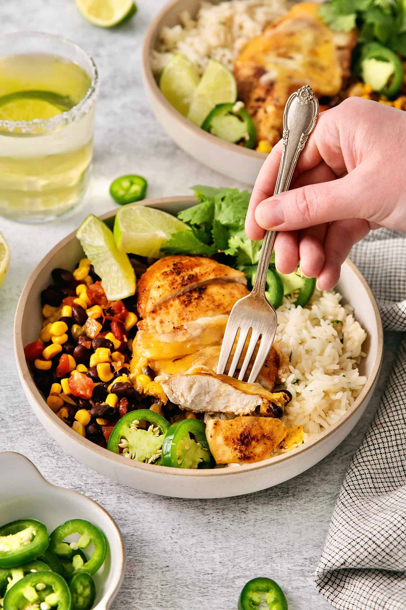 A fork grabbing a piece of cowboy chicken from a rice bowl