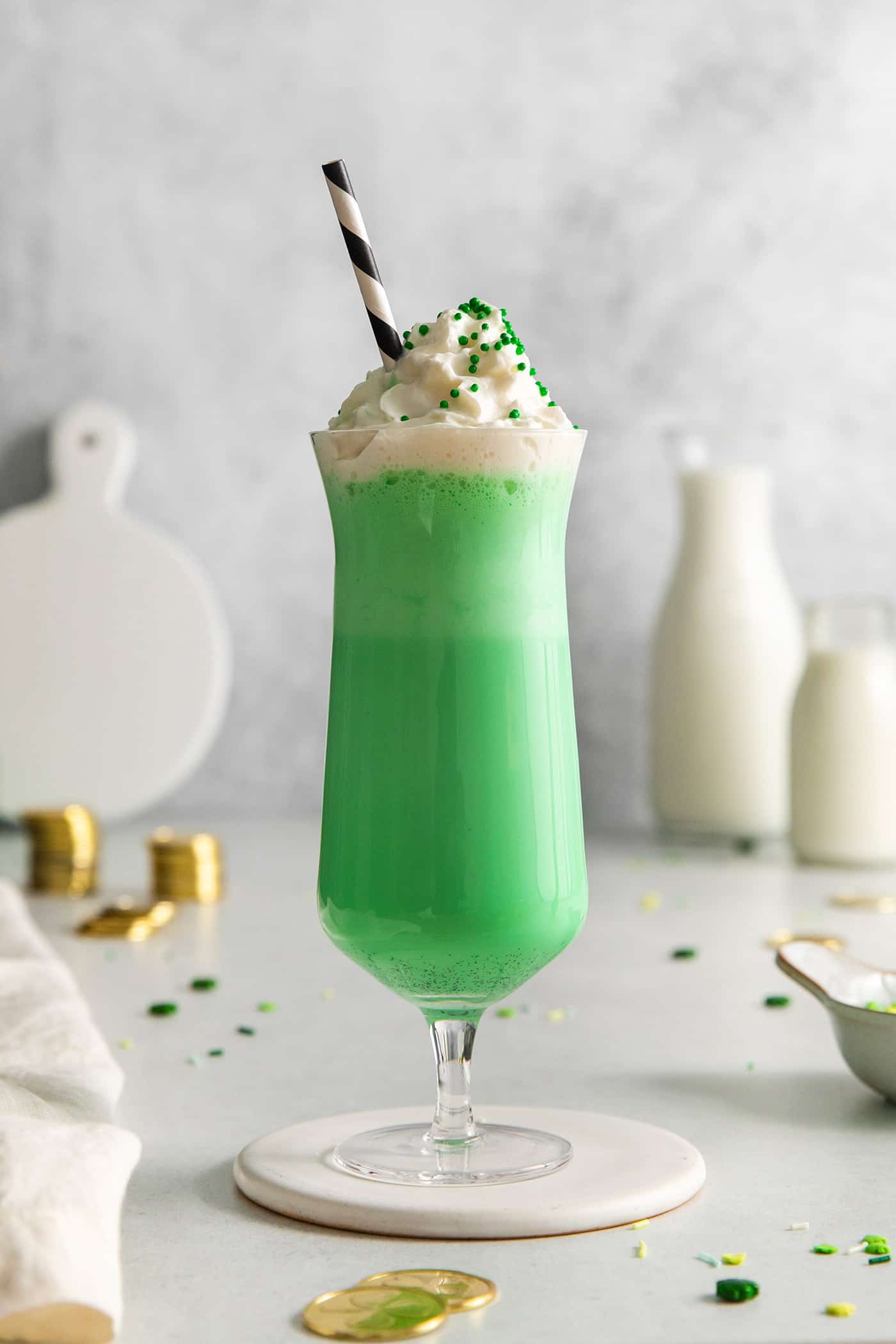 A green mint milkshake in a clear glass