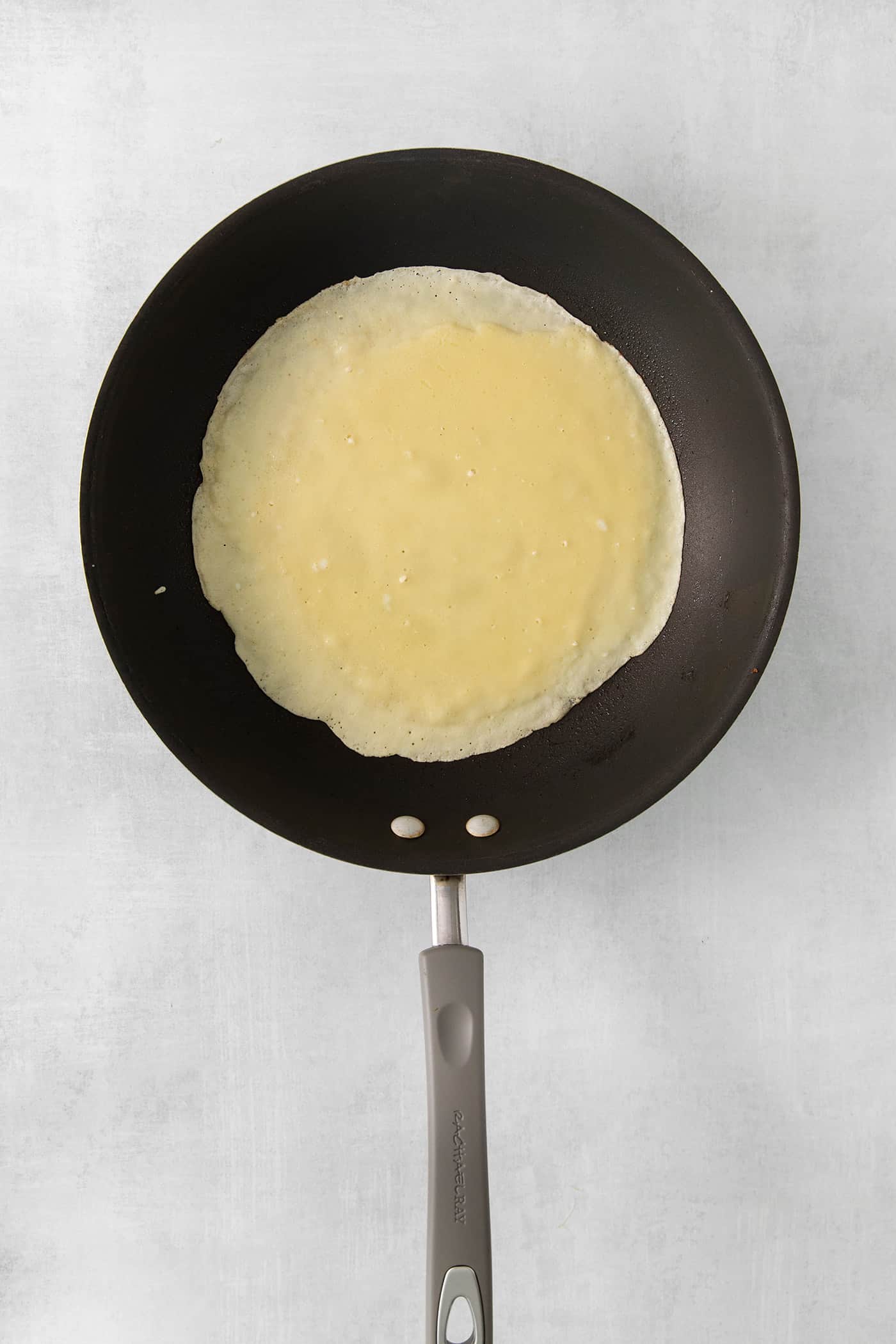 Cooking a crepe in a pan.