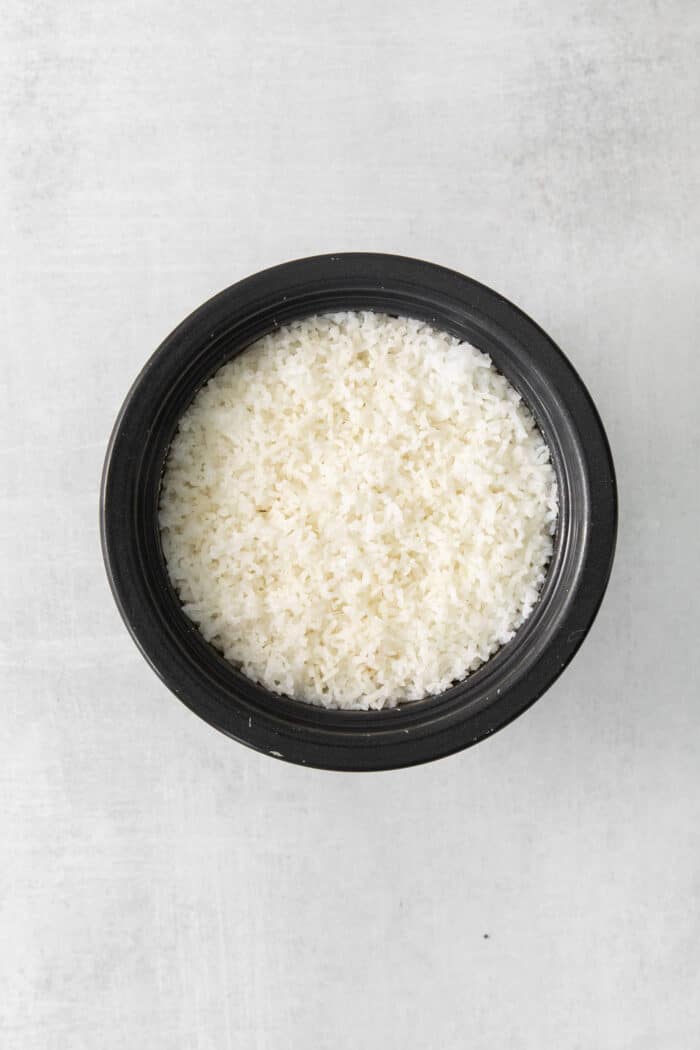 Cooked white rice in a black bowl