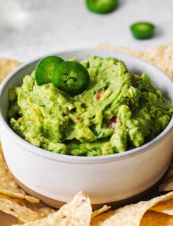 Homemade guacamole in a bowl surrounded by tortilla chips