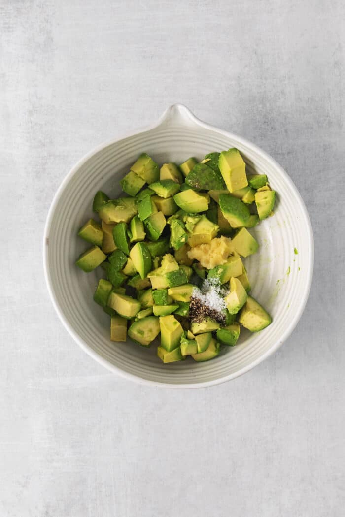 Avocado chunks in a bowl with salt and pepper