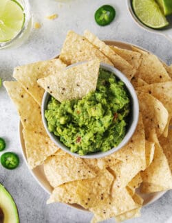 Overhead view of a bowl of classic guacamole with a tortilla chip