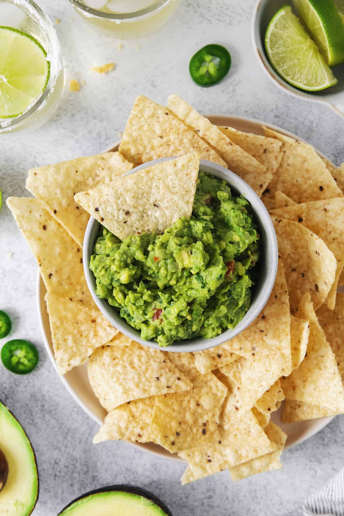 Overhead view of a bowl of classic guacamole with a tortilla chip