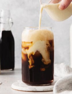 Oatmilk being poured into a brown sugar shaken espresso