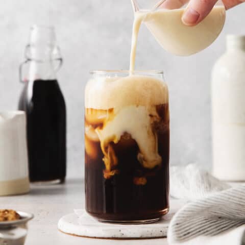 Oatmilk being poured into a brown sugar shaken espresso