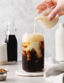 Oatmilk being poured into a brown sugar shaken espresso