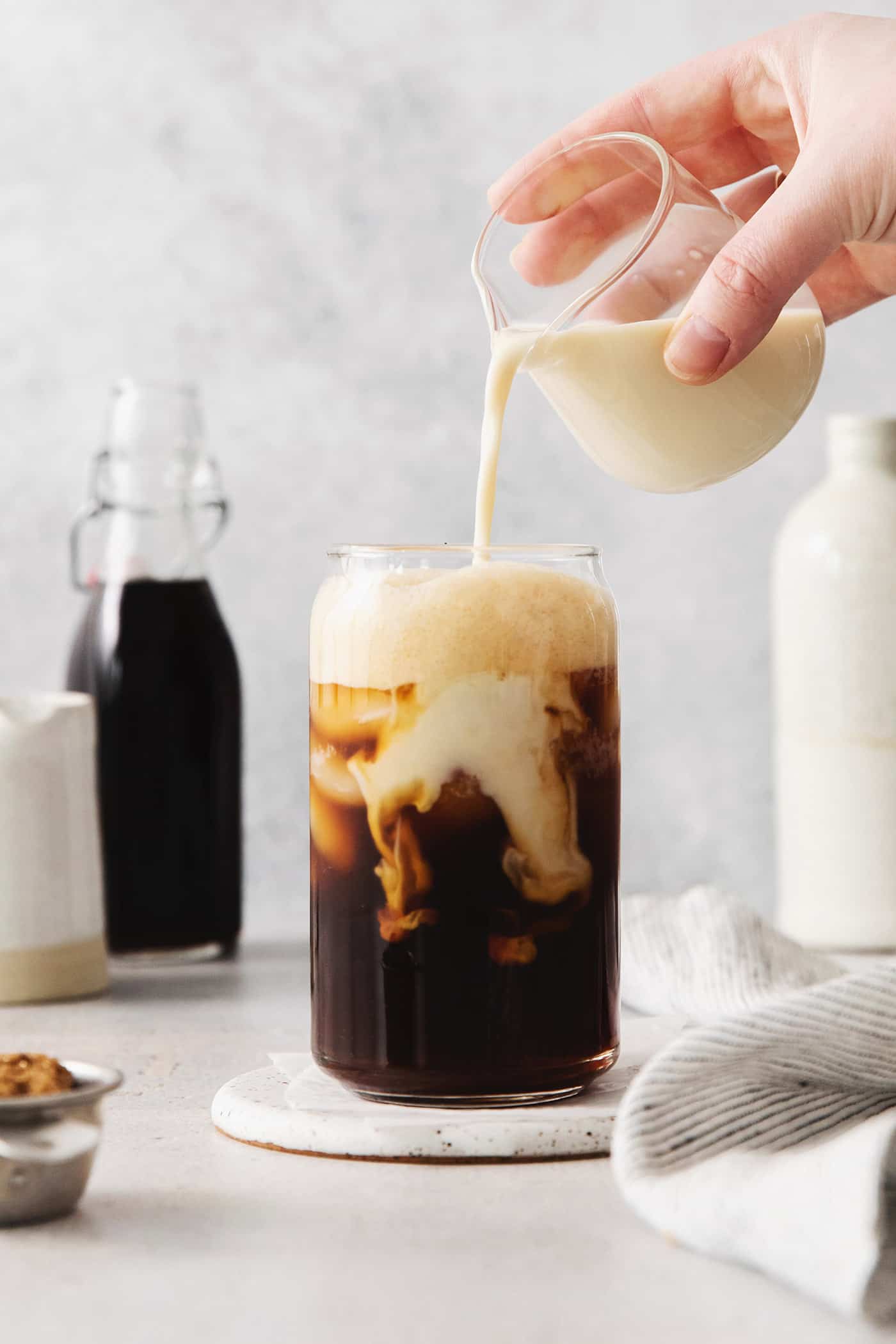 Oatmilk being poured into a brown sugar shaken espresso